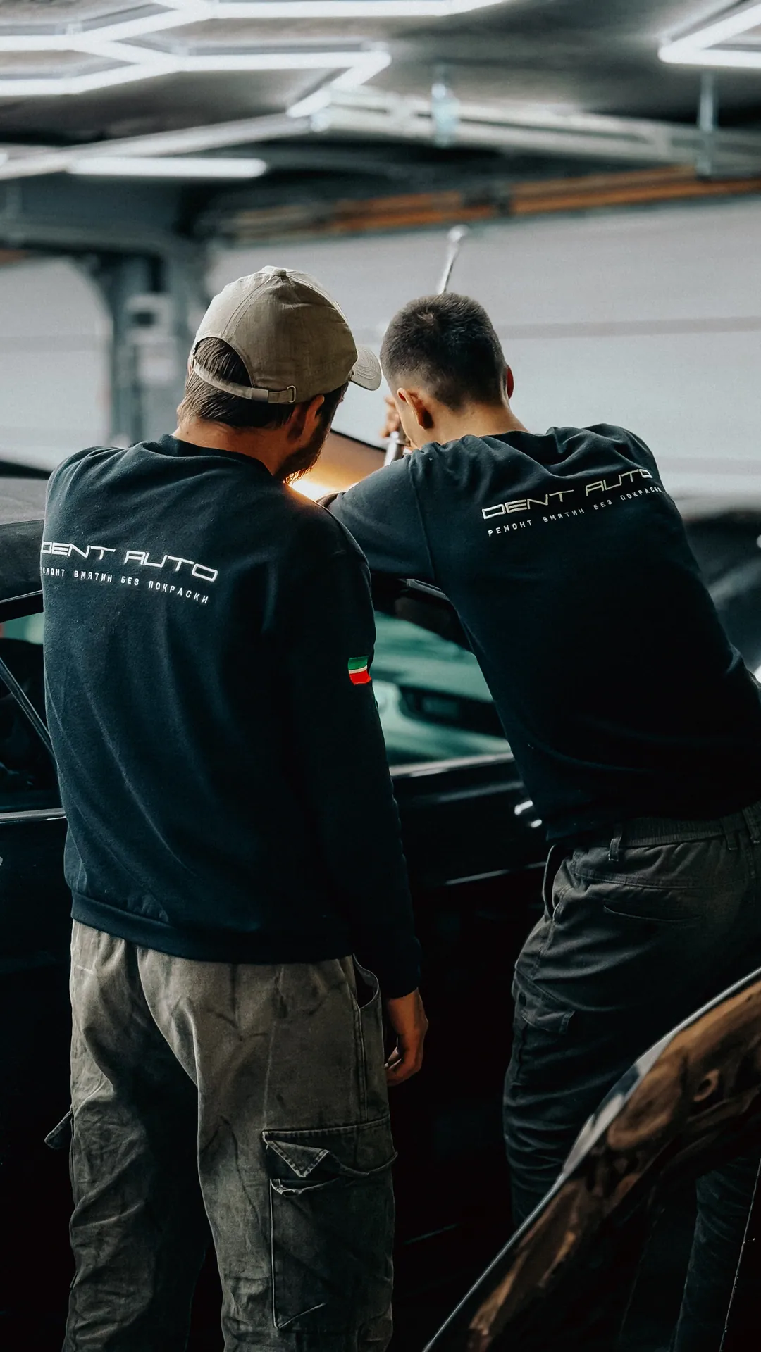 Два мастера Dent Auto вместе работают над автомобилем